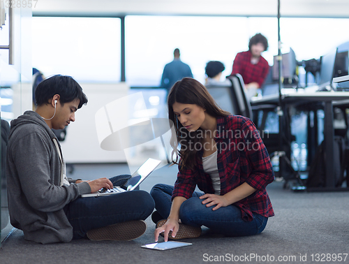 Image of young software developers couple working on the floor