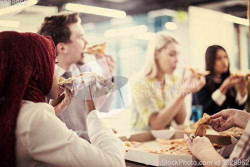 Image of multiethnic business team eating pizza