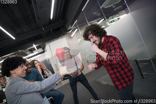 Image of multiethnics business team boxing at office