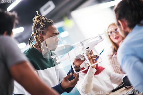 Image of multiethnic business team learning about drone technology