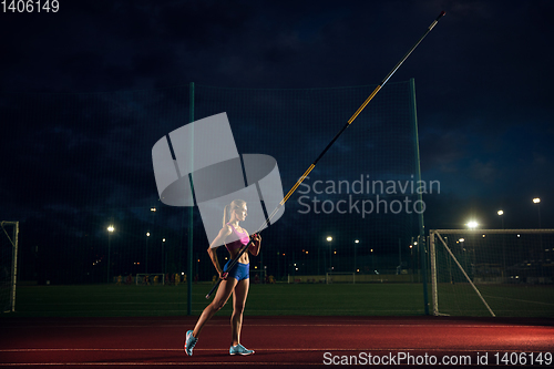 Image of Female pole vaulter training at the stadium in the evening