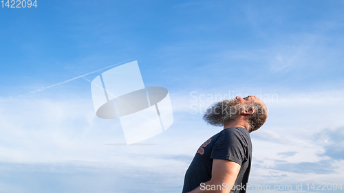 Image of man looking up to the blue sky