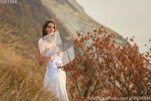 Image of Beautiful girl with wild flowers on the background of a beautiful landscape