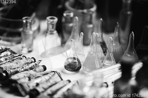 Image of Many Old Deutsch Vintage Medical Glass Capacity. Detail Of Retro Chemical Pharmaceutical Science Researches. Small Bottles Different Sizes From Times Of World War II. WW2 WWII. Black And White