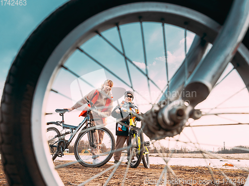 Image of Caucasian Happy Mother And Son Riding Together And Posing For Photo. View From Bicycle Wheel, Family Riding Bicycles. Mothers Day, Mother Day, Mothersday Holiday. Healthy Lifestyle On Spring Nature