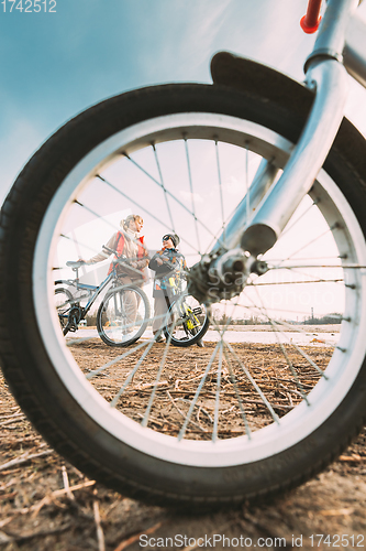 Image of Caucasian Happy Mother And Son Riding Together And Posing For Photo. View From Bicycle Wheel, Family Riding Bicycles. Mothers Day, Mother Day, Mothersday Holiday. Healthy Lifestyle On Spring Nature