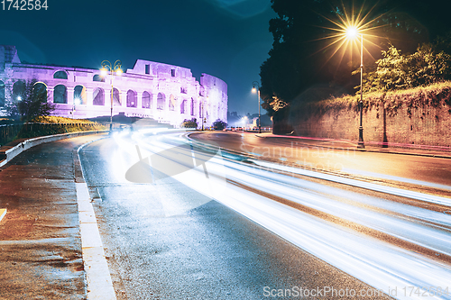 Image of Rome, Italy. Colosseum View From Another Side In Night Time. Night Traffic Light Trails Near Famous World Landmark