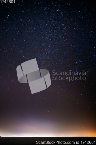 Image of Night Starry Sky With Glowing Stars Above Countryside Landscape. Milky Way Galaxy And Rural Field Meadow In Early Spring. Bright Glowing Stars