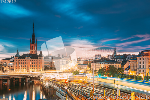 Image of Stockholm, Sweden. Scenic View Of Stockholm Skyline At Summer Sunset. Riddarholm Church And Subway Railway With Train In Blurred Motion