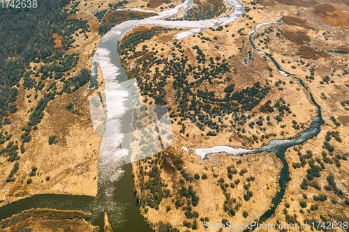 Image of Aerial View Curved River In Early Spring Landscape. River bends Curves and dry grass landscape. Top View Of Beautiful European Nature From High Attitude. Drone View. Bird\'s Eye View