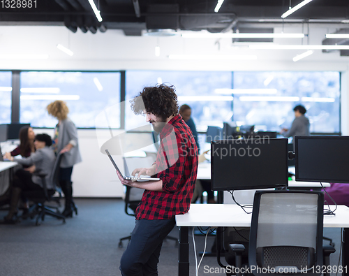 Image of smiling male software developer using laptop