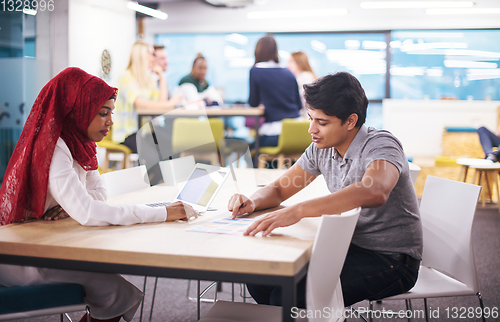 Image of black muslim business woman having a meeting with her indian mal