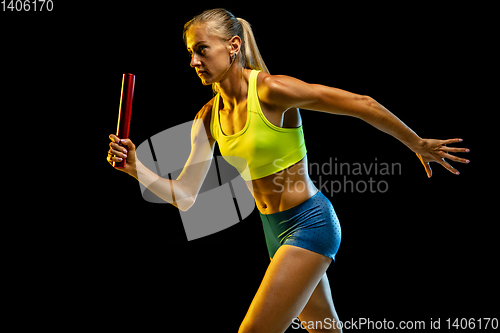 Image of Professional female relay racer training on black studio background in neon light