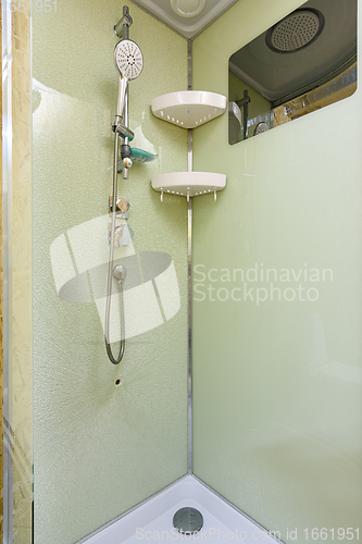 Image of At the back wall of the shower stall on which the mixer and shower are located the glass cracked