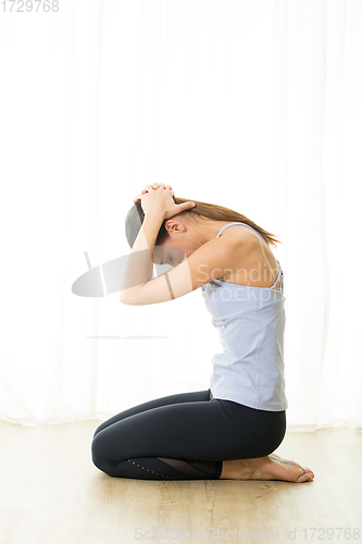 Image of Portrait of gorgeous active sporty young woman practicing breathing exercises in yoga studio. Healthy active lifestyle, working out indoors in gym