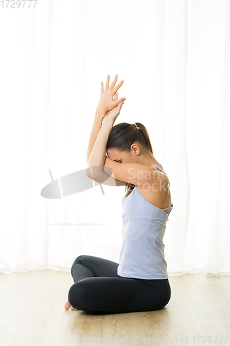 Image of Portrait of gorgeous active sporty young woman practicing breathing exercises in yoga studio. Healthy active lifestyle, working out indoors in gym