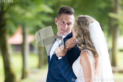 Image of Bride and groom hugging tenderly posing during photo shooting in park.