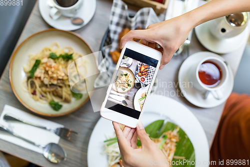 Image of Top view of woman taking photo on dishes