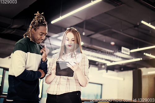 Image of multiethnic business couple using a tablet computer