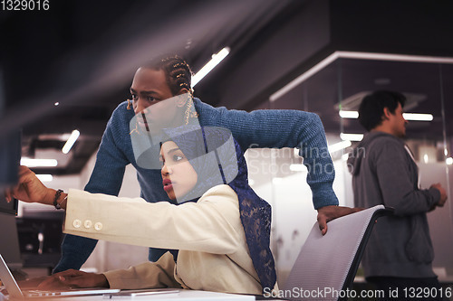 Image of young black muslim female software developer at work