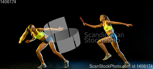 Image of Professional female relay racer training on black studio background in neon light