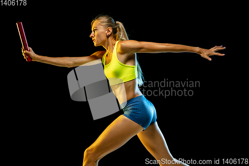 Image of Professional female relay racer training on black studio background in neon light