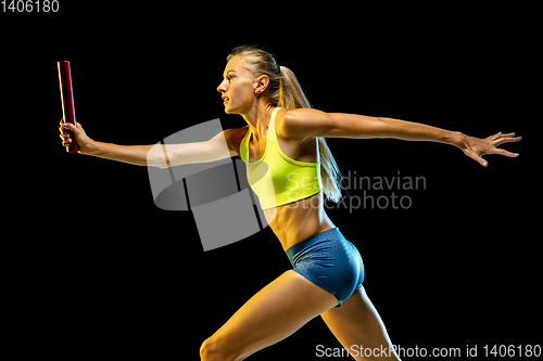 Image of Professional female relay racer training on black studio background in neon light