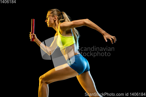 Image of Professional female relay racer training on black studio background in neon light