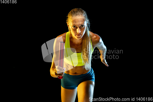 Image of Professional female relay racer training on black studio background in neon light