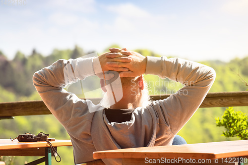 Image of An old man relaxes in the sun