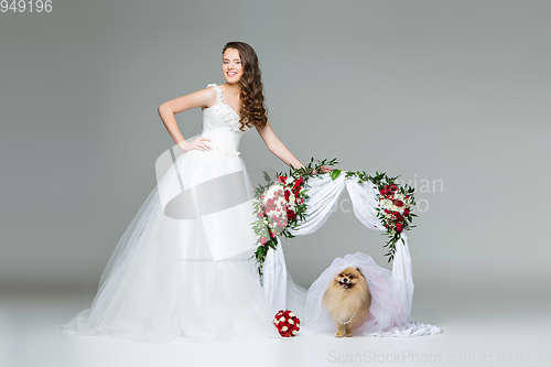 Image of bride girl with dog bride under flower arch