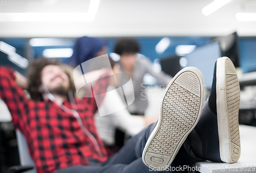 Image of software developer resting with legs on desk