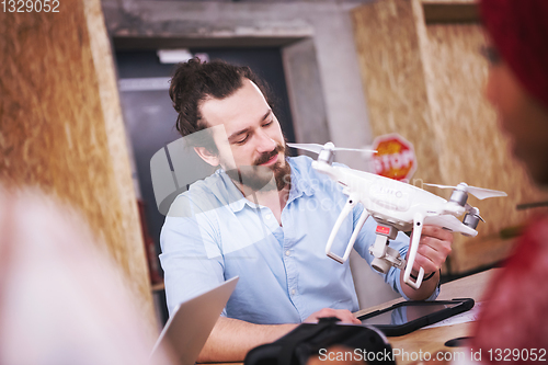 Image of multiethnic business team learning about drone technology