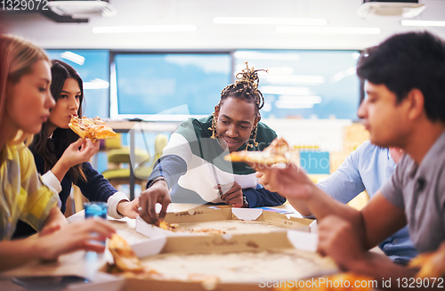 Image of multiethnic business team eating pizza