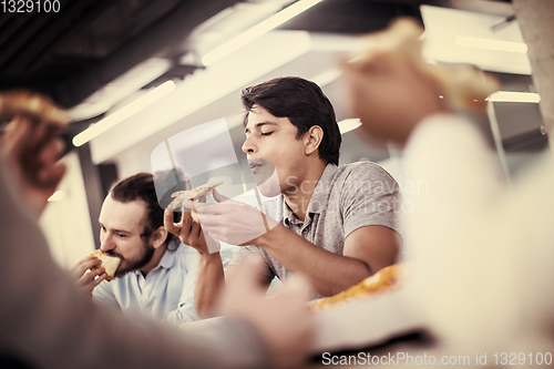 Image of multiethnic business team eating pizza