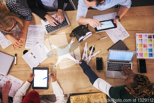 Image of top view of multiethnic business team learning about drone techn