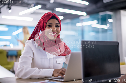 Image of black muslim business woman ,working on laptop computer
