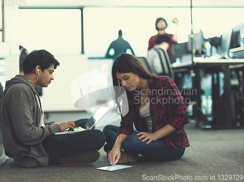 Image of young software developers couple working on the floor