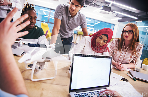 Image of multiethnic business team learning about drone technology