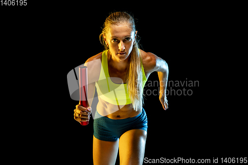 Image of Professional female relay racer training on black studio background in neon light