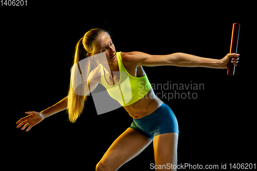 Image of Professional female relay racer training on black studio background in neon light