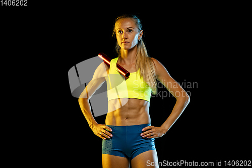 Image of Professional female relay racer training on black studio background in neon light