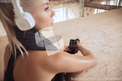 Image of A young athletic woman working out on an abandoned construction site