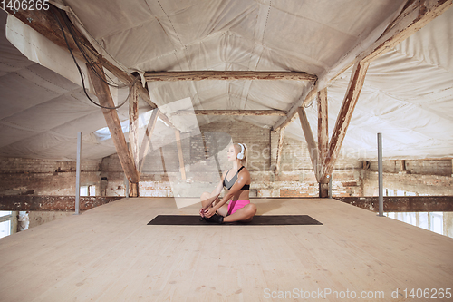 Image of A young athletic woman working out on an abandoned construction site