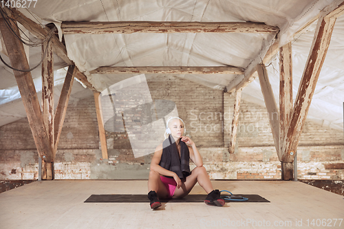Image of A young athletic woman working out on an abandoned construction site