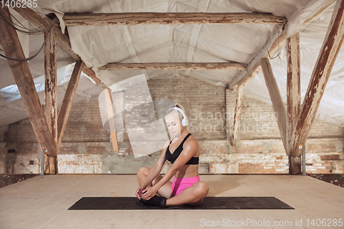 Image of A young athletic woman working out on an abandoned construction site