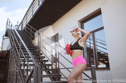 Image of A young athletic woman working out on a stairs outdoors