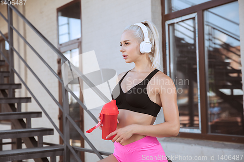 Image of A young athletic woman working out on a stairs outdoors