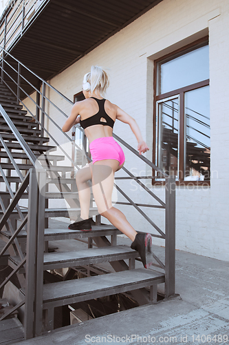 Image of A young athletic woman working out on a stairs outdoors