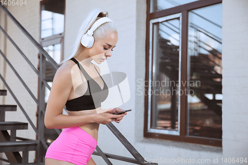 Image of A young athletic woman working out on a stairs outdoors